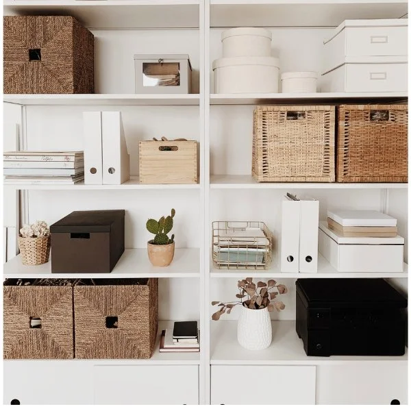 Neatly organized white shelving unit with baskets, boxes, and bins representing home organizing services in Brentwood TN