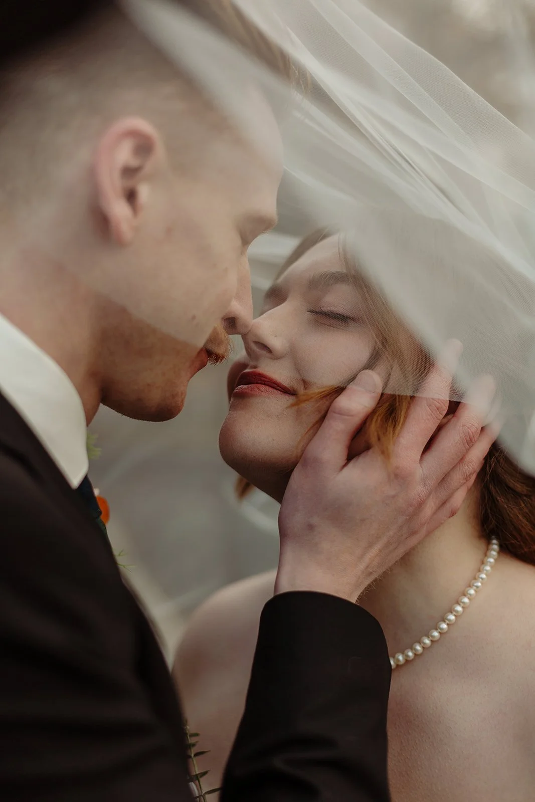 Couple embracing under the brides veil on their wedding day in Ottawa, Ontario
