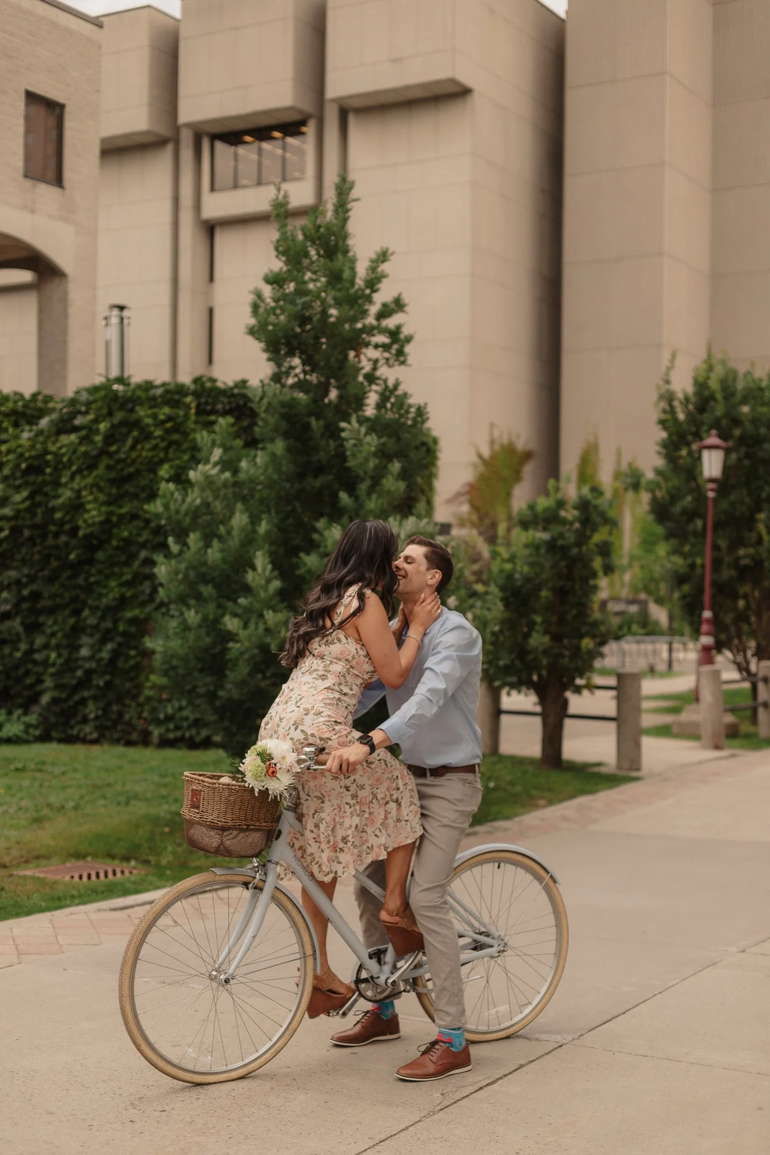Engaged couple playfully kiss on their bike in Ottawa, Ontario