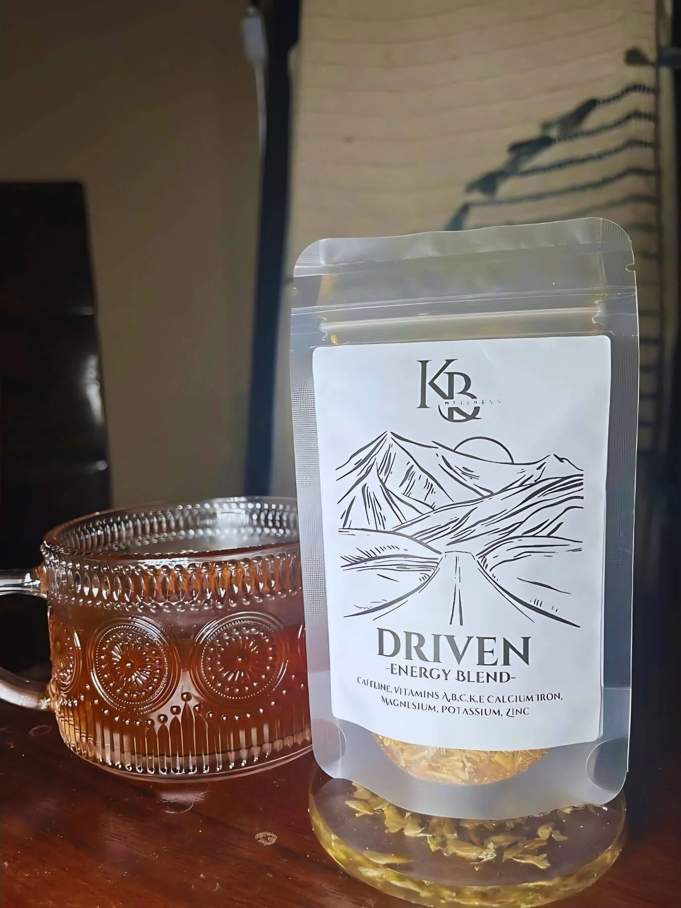 Driven herbal tea pouch beside  a freshly brewed cup of tea.
