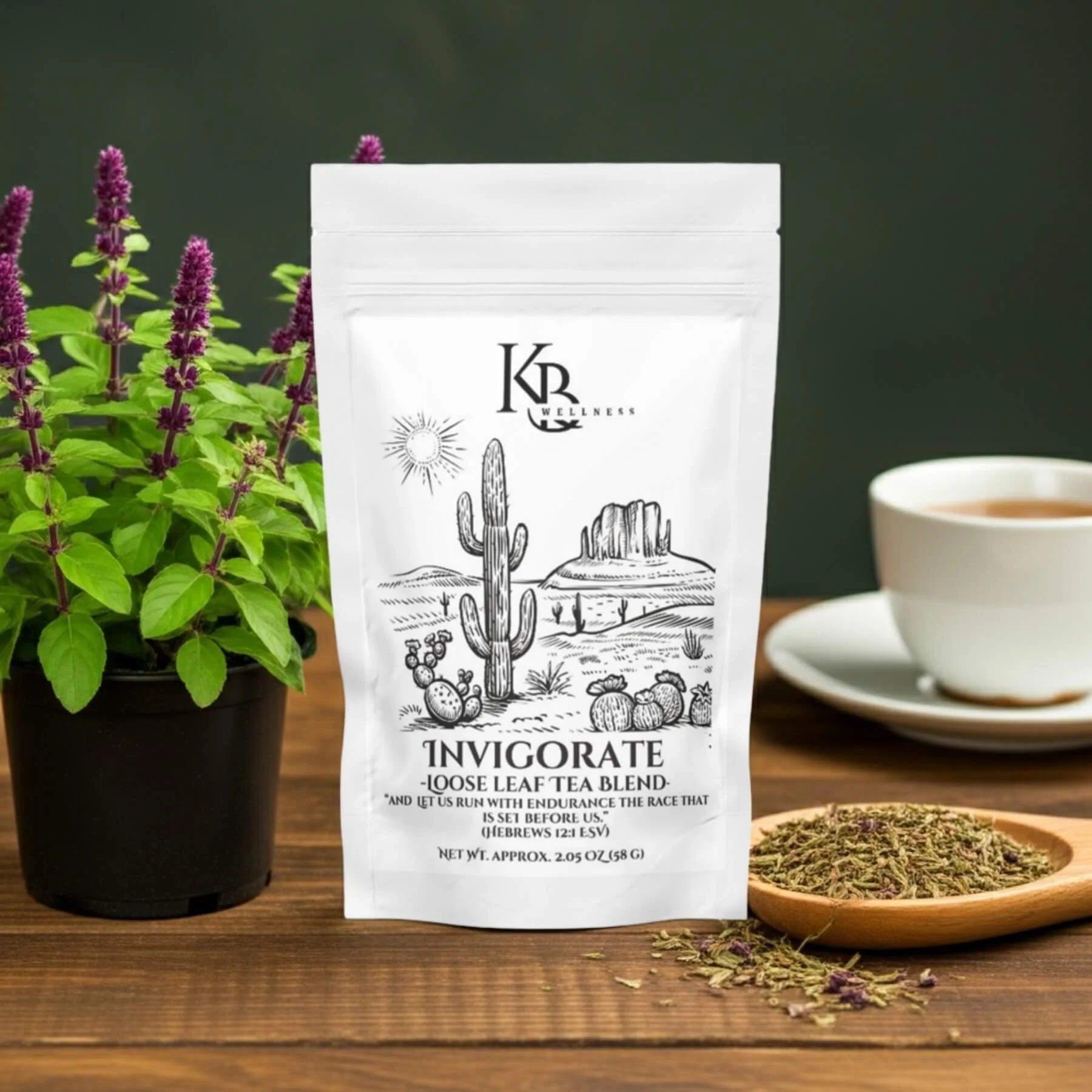 Invigorate herbal tea in it's packaging on a wooden table next to a holy basil plant, spme dried herbs, and a teacup in the background.