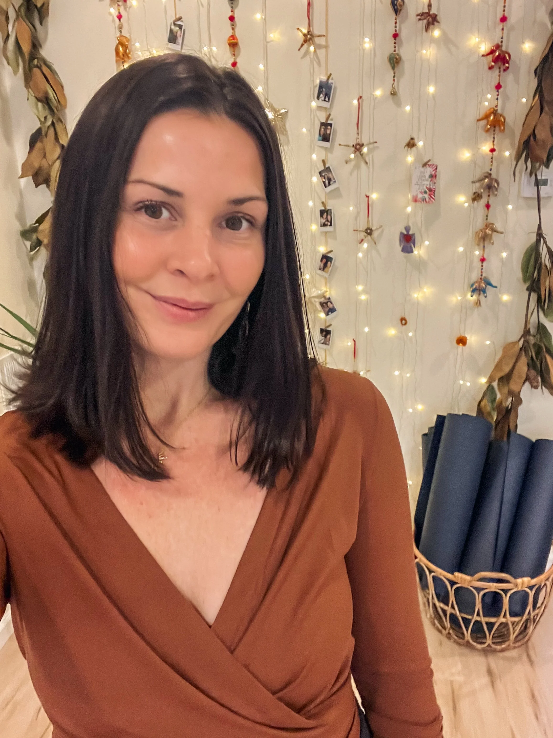 A woman with  dark hair smiling in front of a barn door.