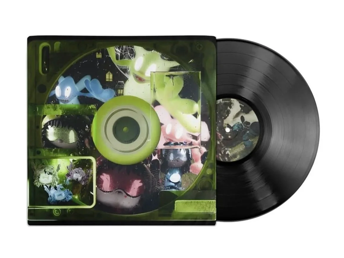 A vinyl record and colorful album cover featuring cartoonish monsters and spooky house illustrations.