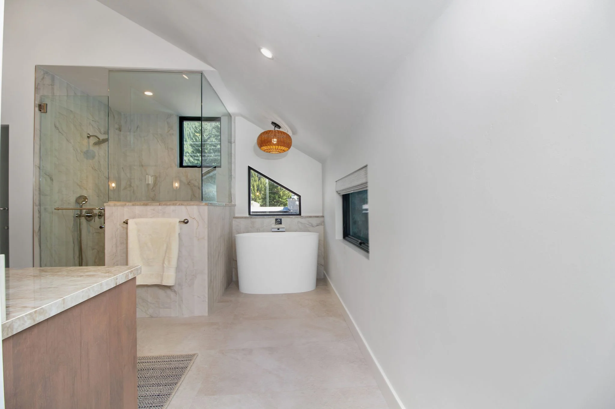 The bathroom retained its generous footprint while receiving a complete luxury update. The redesigned space features a Japanese soaking tub, oversized walk-in shower, custom California Closets storage system designed for two, and a dedicated washer a