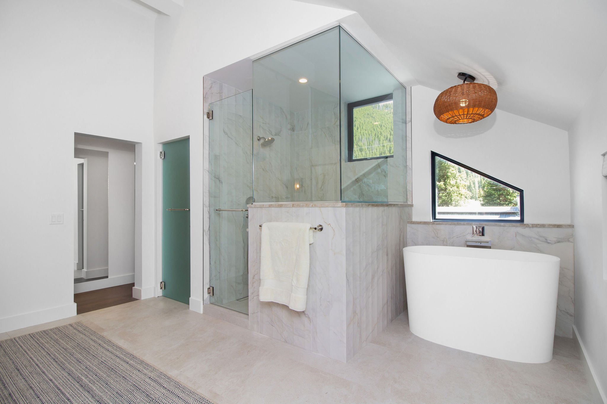 This bathroom retained its generous footprint while receiving a complete luxury update. The redesigned space features a Japanese soaking tub, oversized walk-in shower, custom California Closets storage system designed for two, and a dedicated washer 