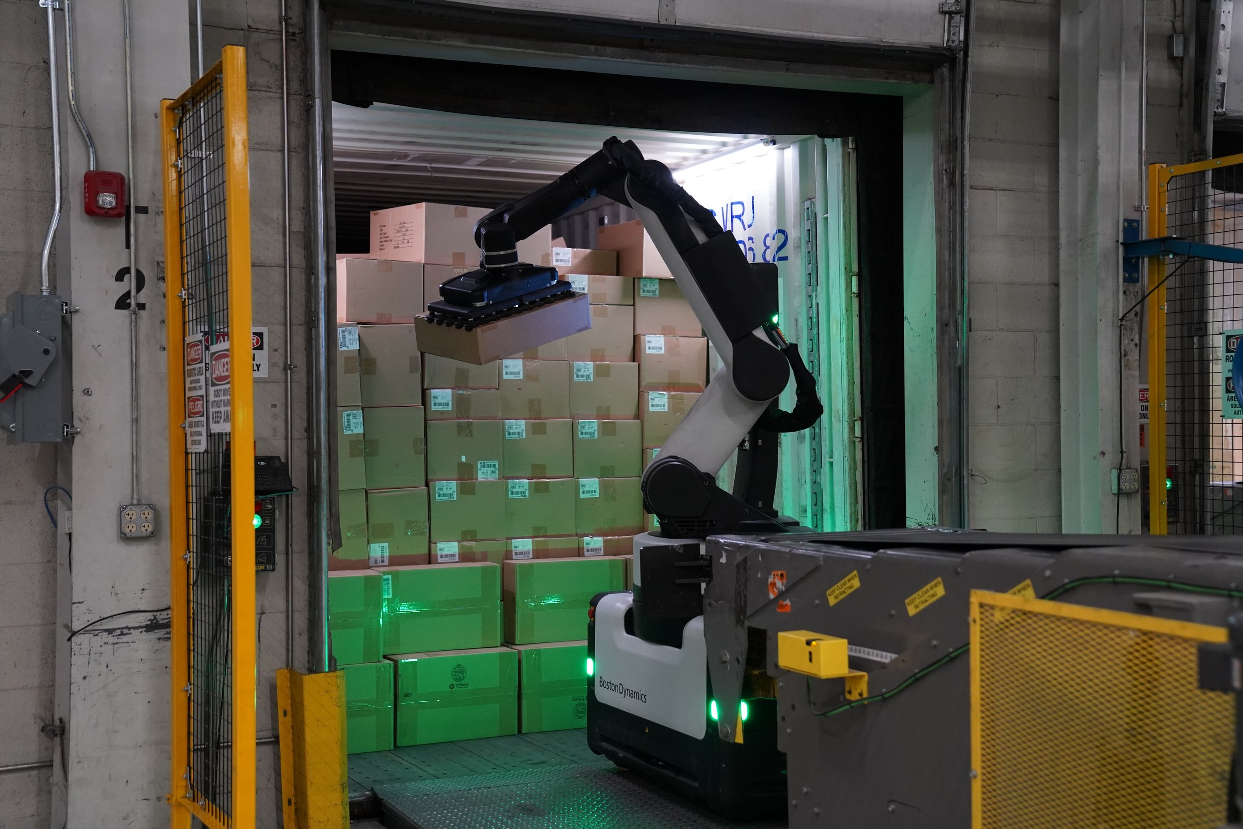 Boston Dynamics Stretch robot unloading boxes in a logistics and distribution environment.