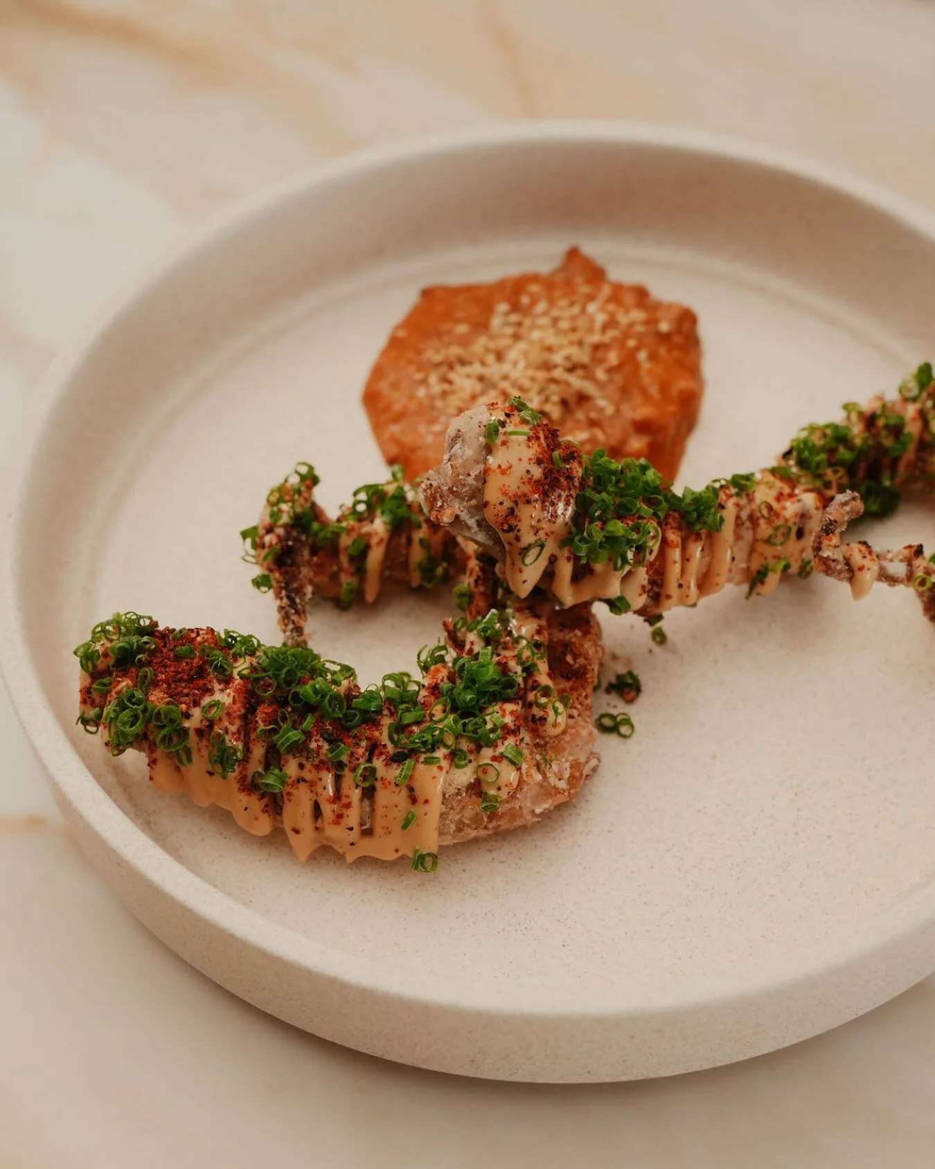 Crispy W.A. octopus with Korean peanut pesto and shichimi.

Best shared with a glass of wine and ocean views.

Available on our lunch and dinner menu.