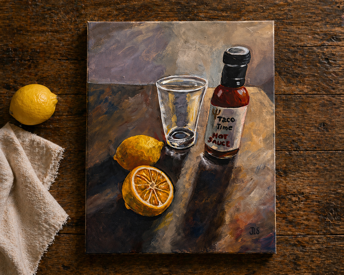 Still life with lemon, cut lemon, glass, and Taco Time hot sauce bottle