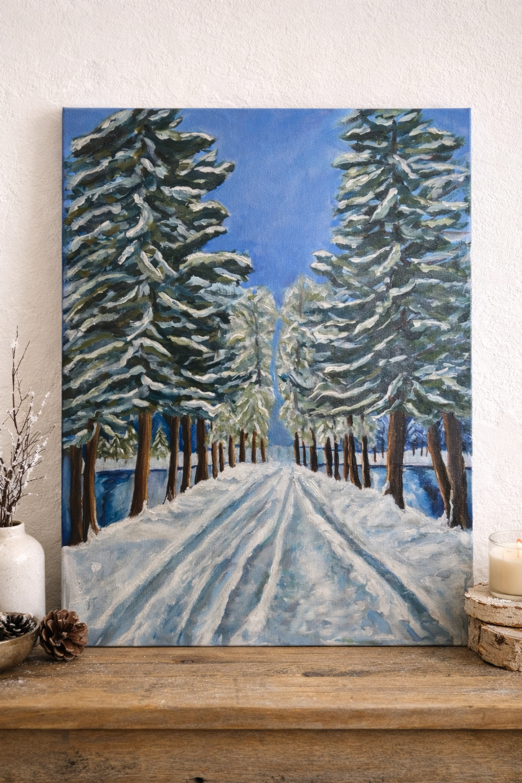 Winter landscape painting of tall evergreen trees covered in snow with a path through the center.