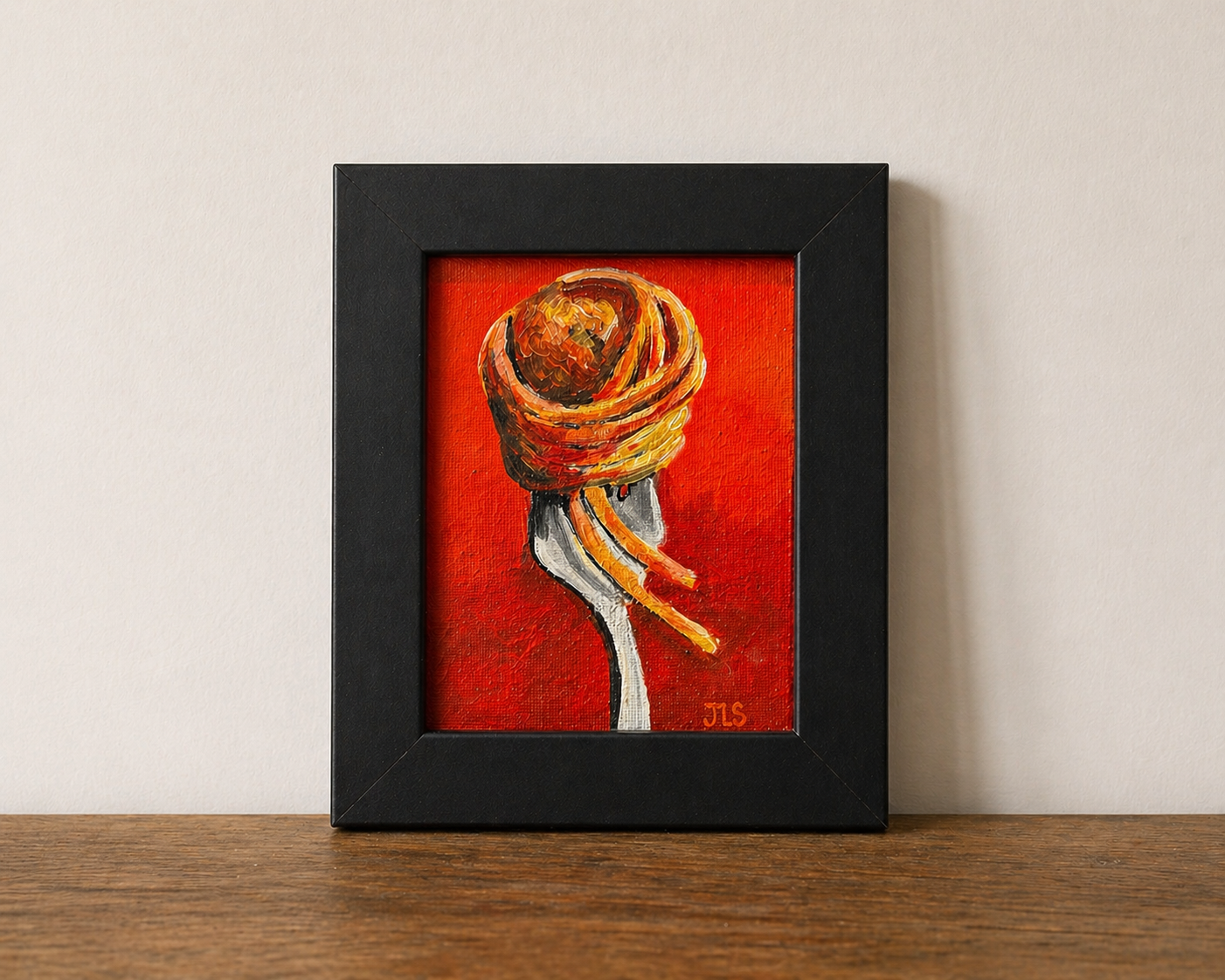 Close view of spaghetti and meatball twirled on a fork with strands hanging down