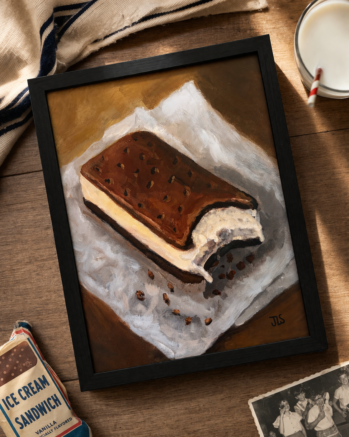 Ice cream sandwich with a bite taken out resting on crinkled paper with scattered crumbs on a tabletop