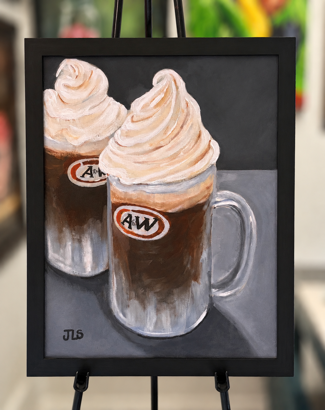 Two vintage-style root beer floats topped with creamy foam in clear glass mugs on a dark reflective surface