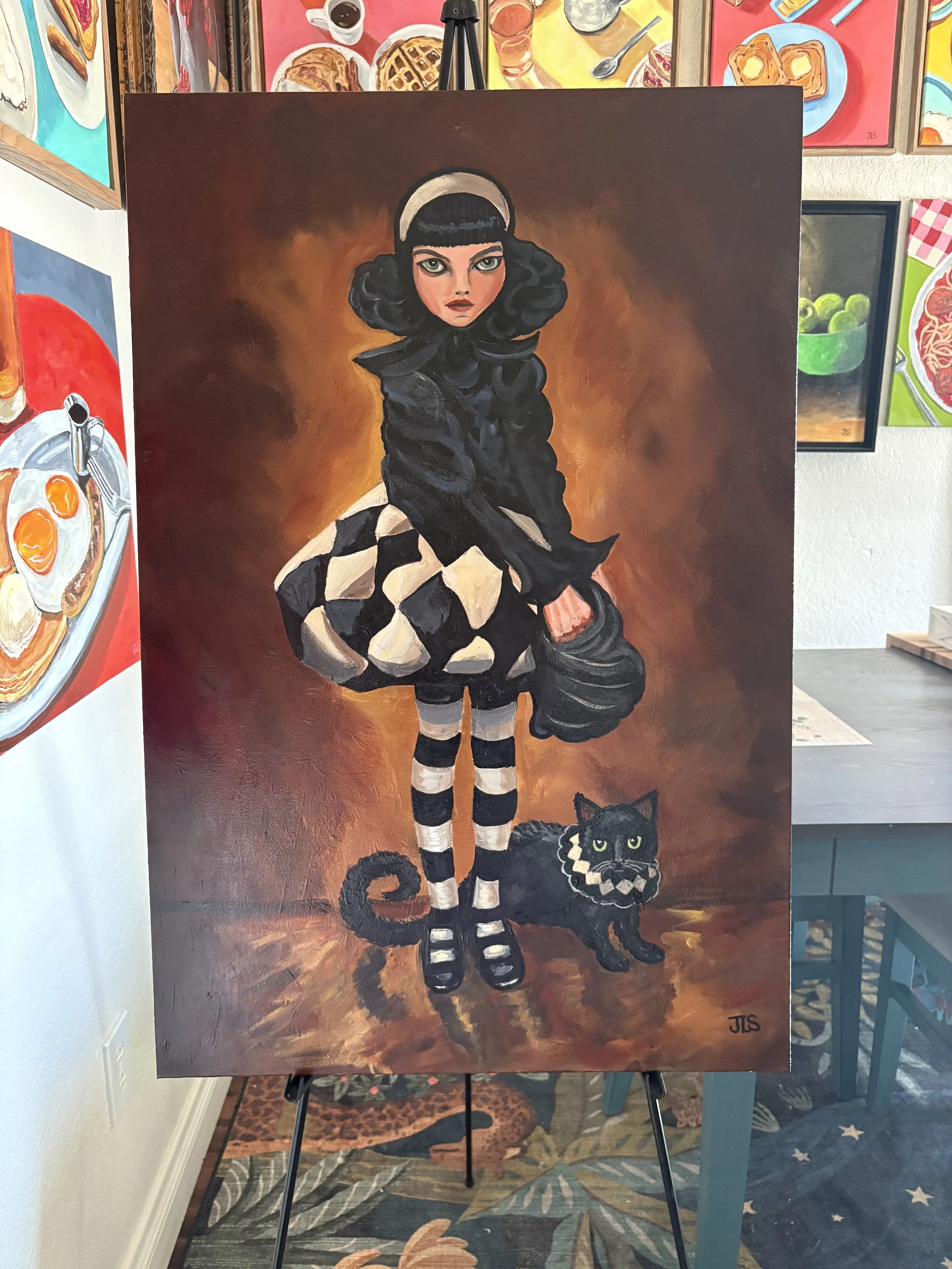Original hand-painted acrylic artwork of a gothic girl named Delilah standing beside her black cat Jasper, wearing coordinating black and cream harlequin details.