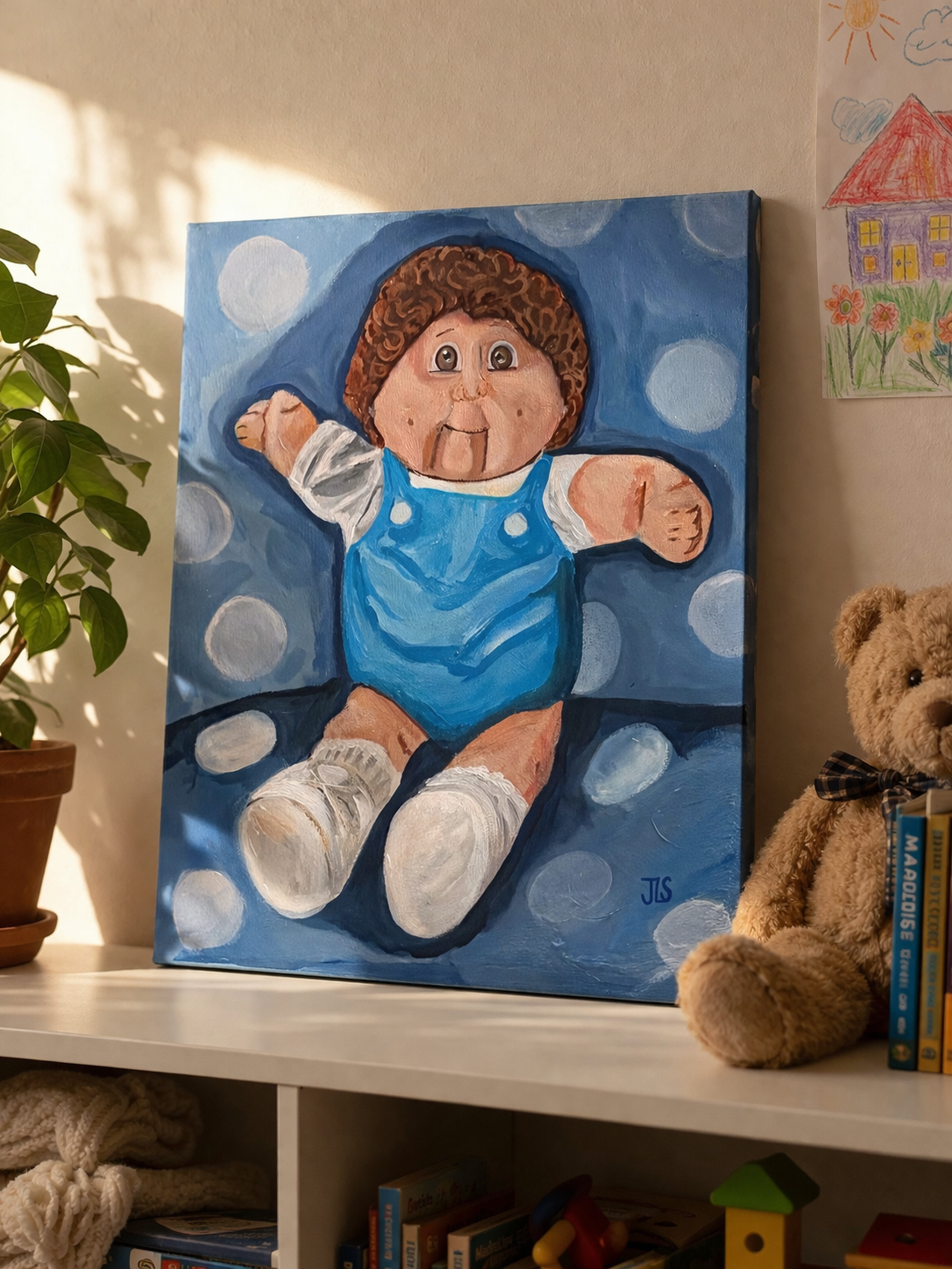 Cabbage Patch doll wearing a blue outfit, lying against a blue background with white polka dots