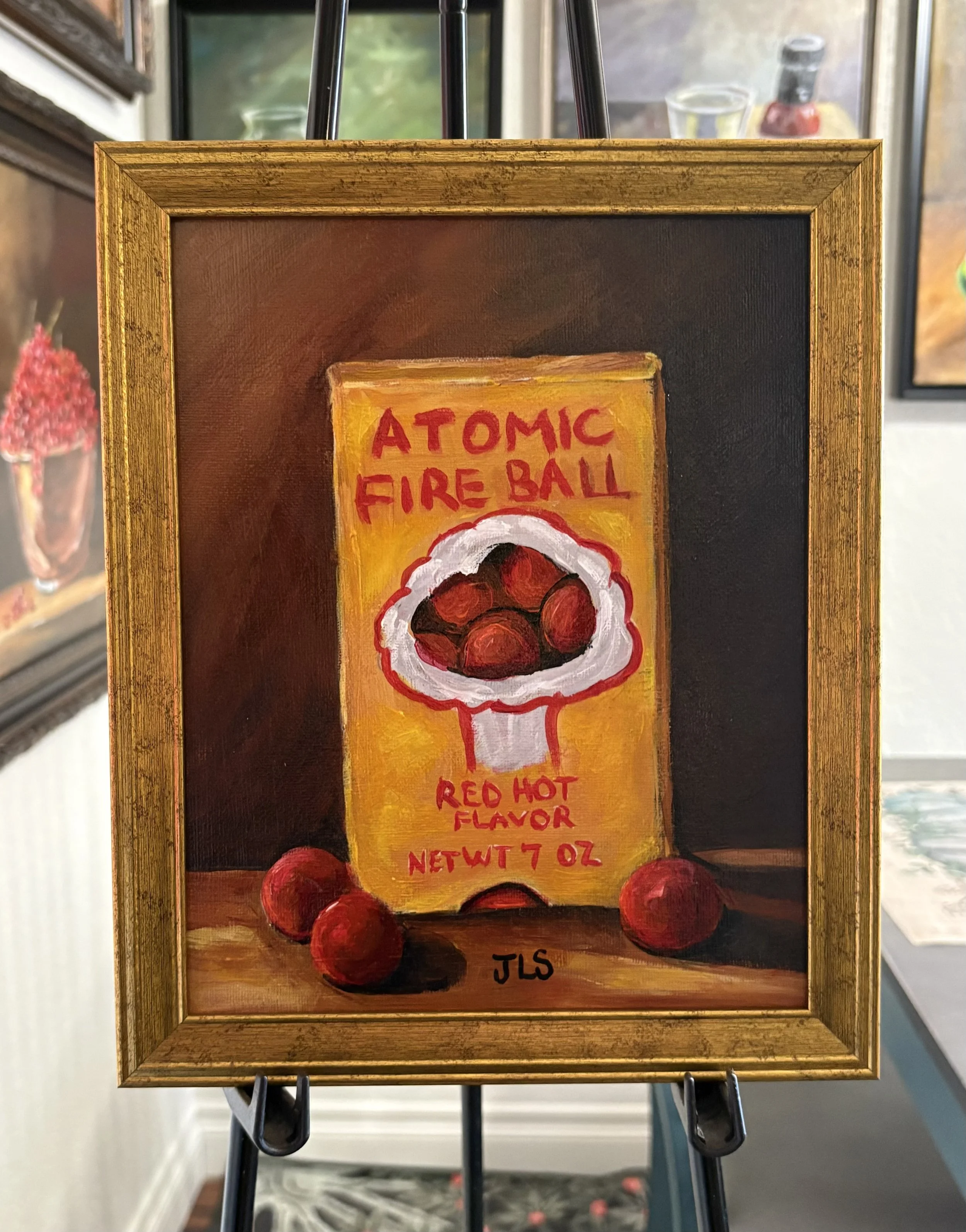 Alt Text Painting of a vintage Atomic Fire Ball candy box, hand painted in acrylic on canvas panel and framed in a wood gold frame.