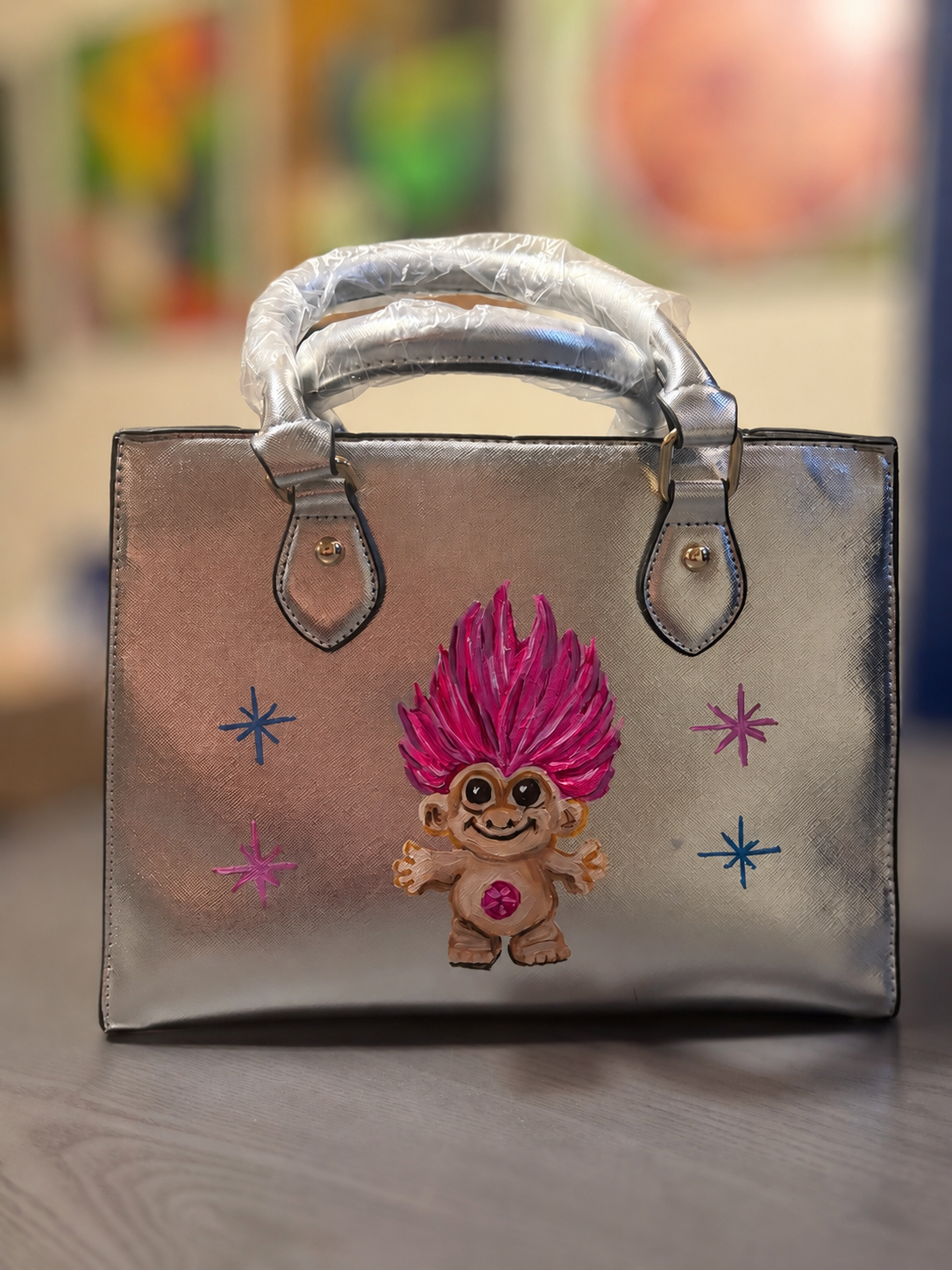 Metallic silver hand-painted troll doll purse with removable shoulder strap, gold-tone hardware, and bright pink hair.