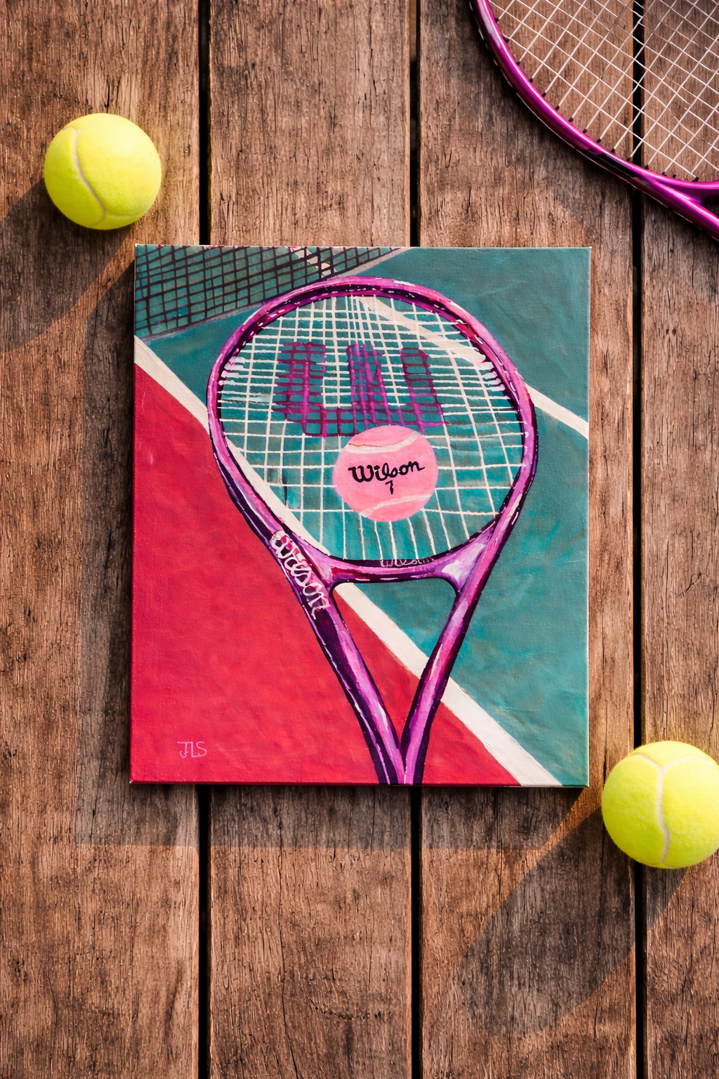 Tennis racket on a court with tennis balls nearby