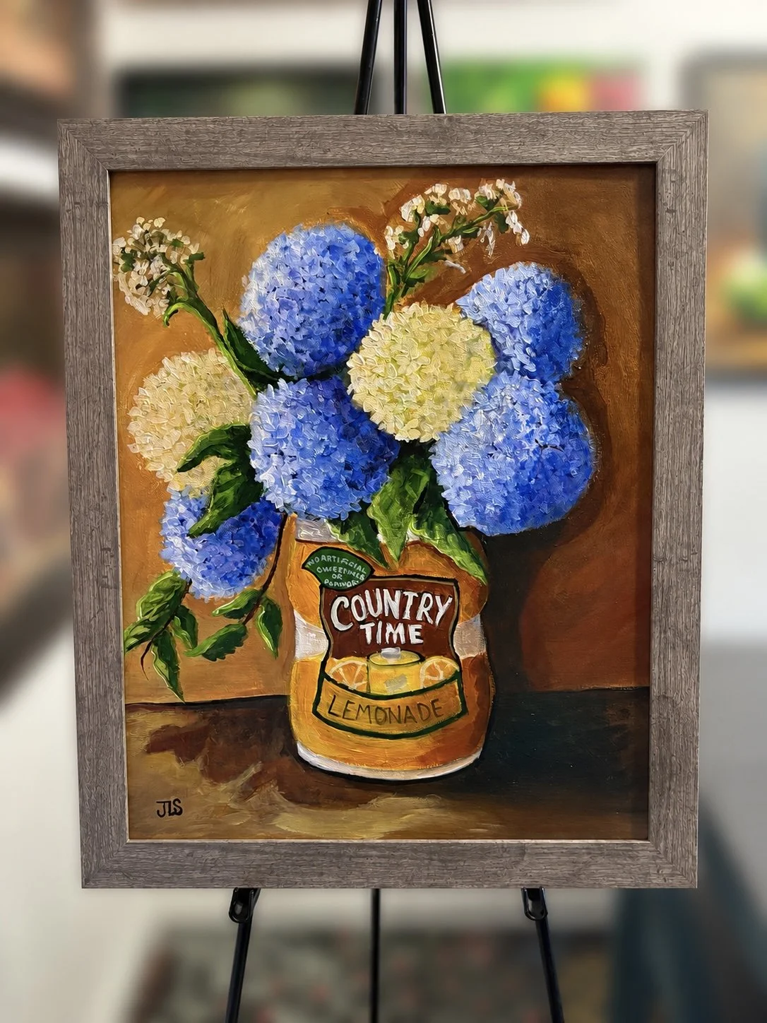 Original still life painting of blue and cream hydrangeas arranged in a vintage Country Time Lemonade container against a warm brown background.