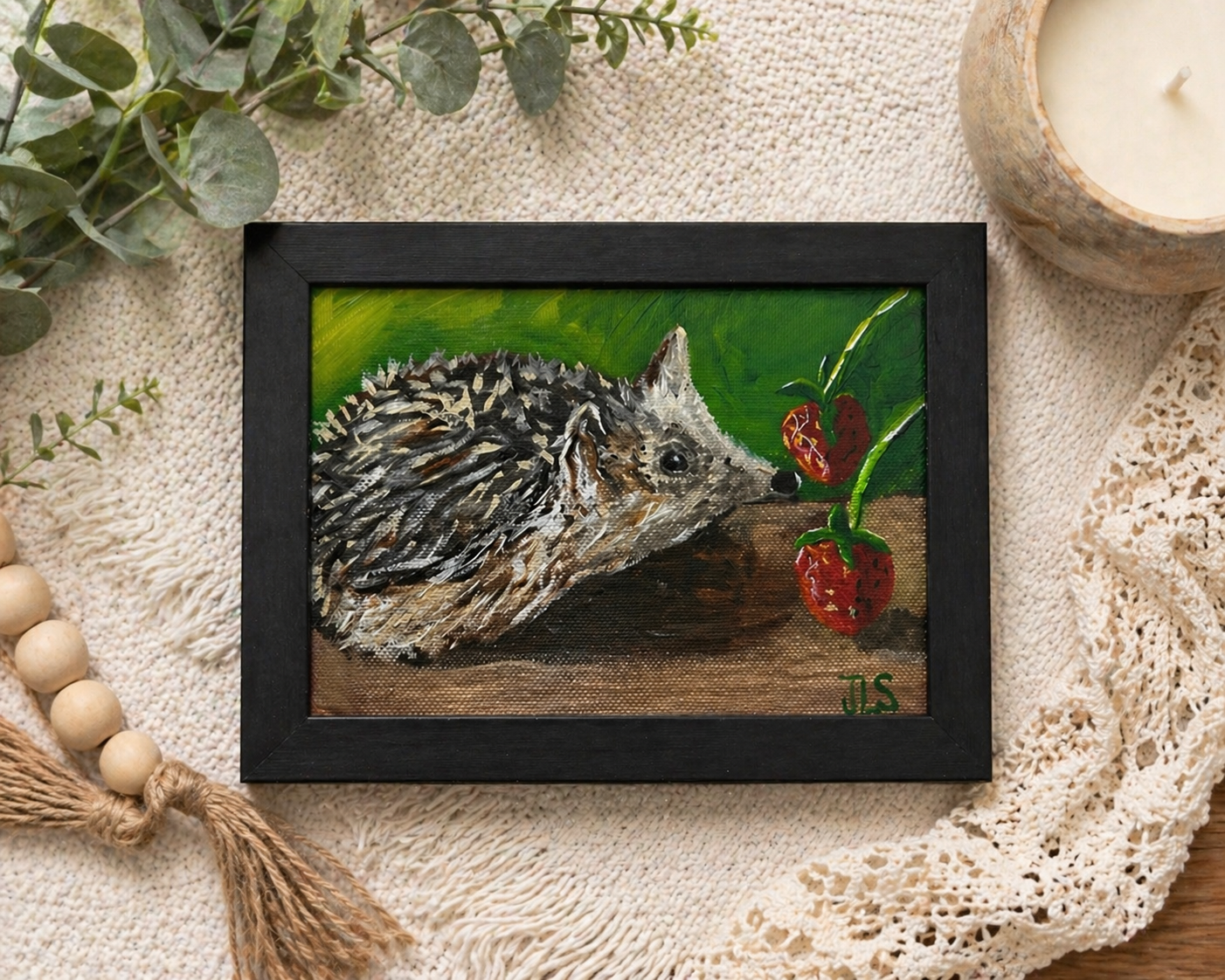 Small hedgehog next to a strawberry on a green background