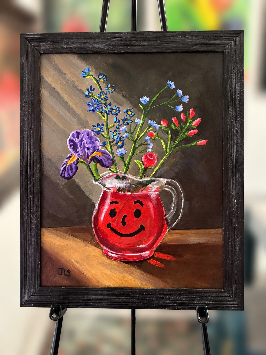 Painting of a colorful bouquet of flowers arranged in a smiling red Kool-Aid pitcher against a dark background with dramatic light and shadow.