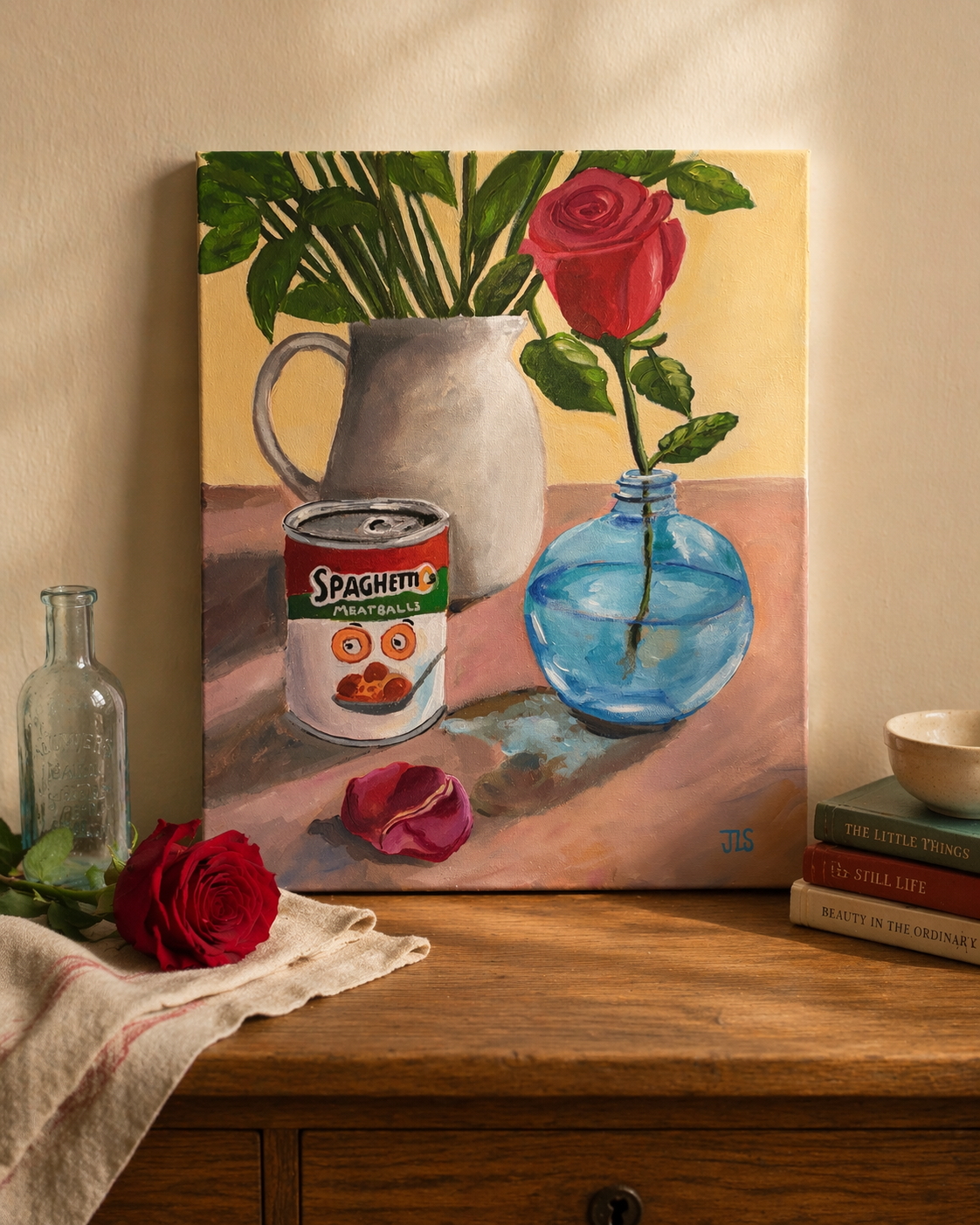 SpaghettiOs can beside white ceramic pitcher with greenery and red rose in blue vase