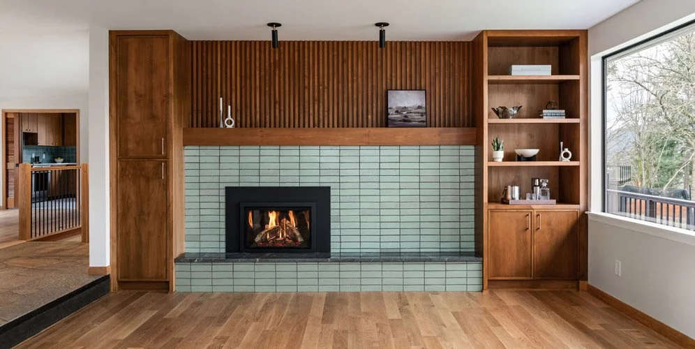 Sammamish WA living room remodel by a design-build contractor featuring a tiled fireplace, custom wood slat wall, and built-in shelving in a mid-century home