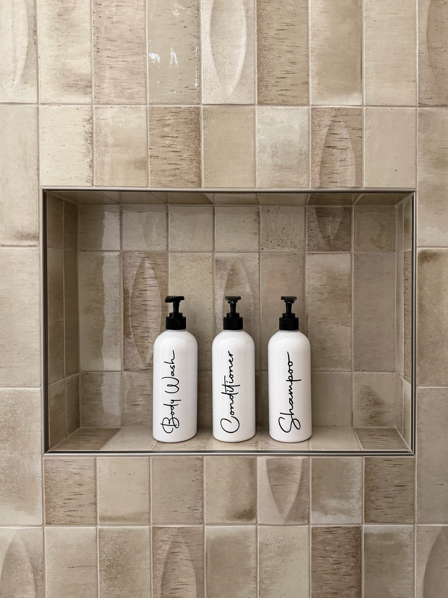 Close-up of the shower niche and tile detail in a Gig Harbor bathroom remodel, designed and finished by a remodeling contractor with built-in bath product storage.