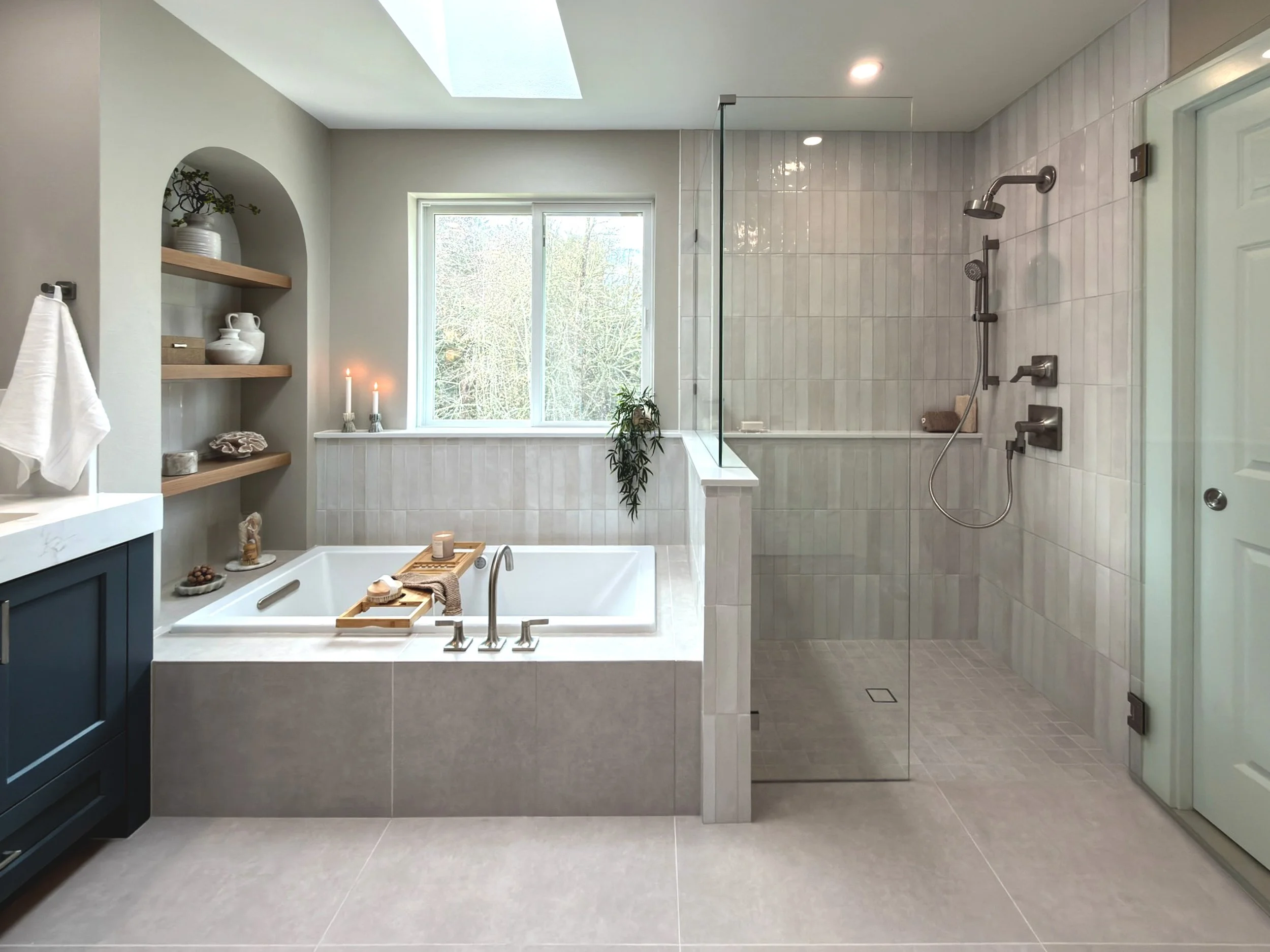 Walk-in shower and soaking tub combination in a Sammamish bathroom remodel with skylight, large window, and modern tile surround