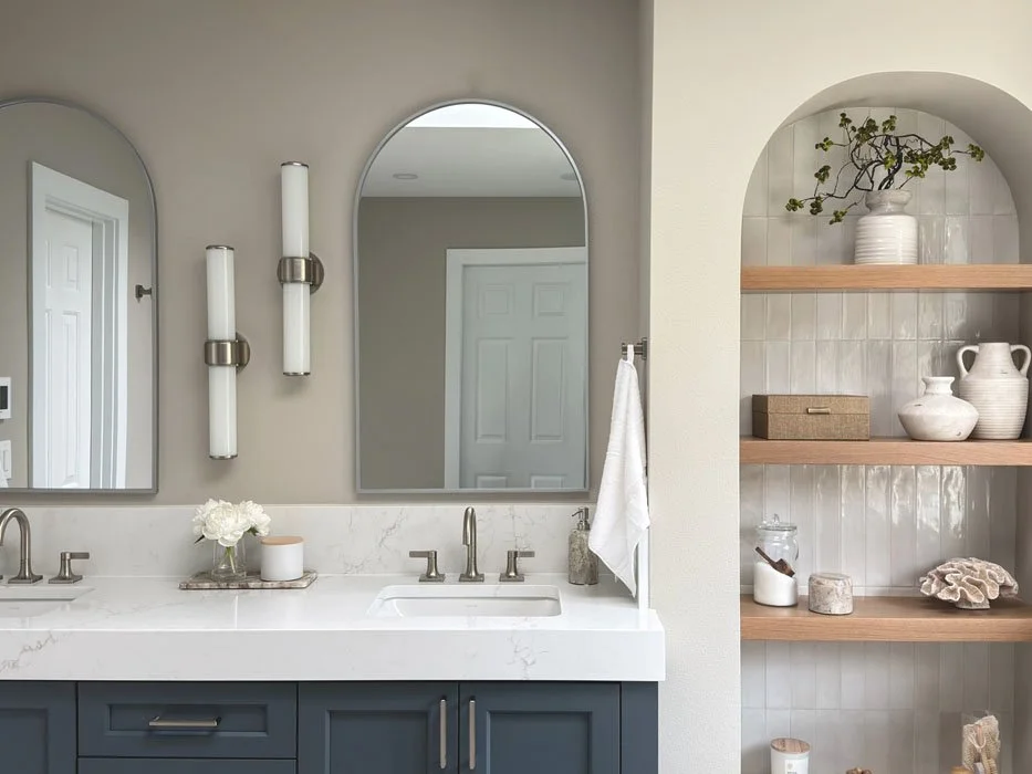 Modern bathroom vanity with arched mirror, wall sconces, and quartz countertop in a Sammamish bathroom remodeling project