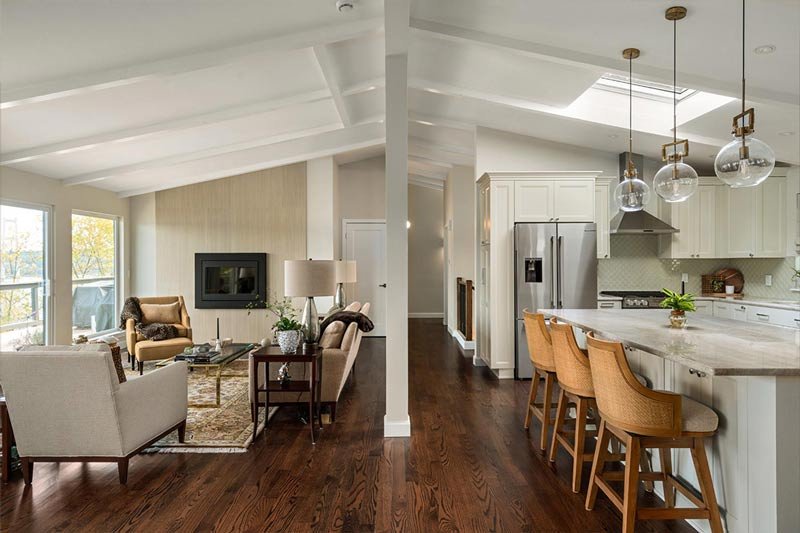 After photo of the remodeled living room and kitchen in a Gig Harbor home, updated by a remodeling contractor with an open-concept layout, vaulted ceiling, and modern finishes.