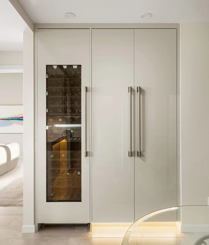 Browns Point Tacoma WA luxury kitchen remodel by a design build contractor featuring integrated refrigerator, wine column, warm grey cabinetry, and custom European style cabinetry