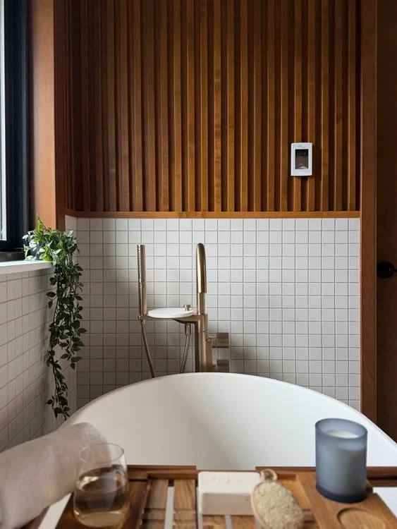 Sammamish WA bathroom remodel by a design-build remodeling contractor featuring a freestanding soaking tub, mid-century tile, and custom wood slat accent wall