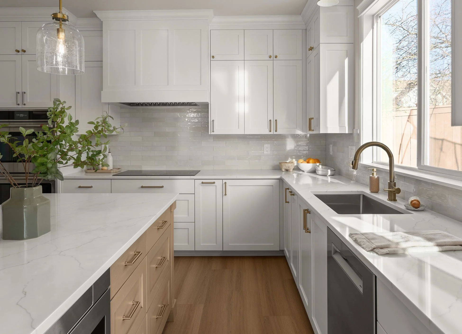 Kitchen remodel in Maple Valley with white shaker cabinets, brass fixtures, and quartz countertops