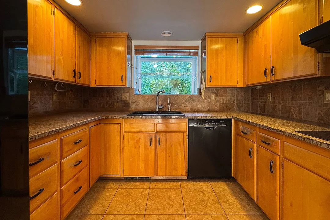 Before photo of a Sammamish WA kitchen remodel showing original 1960s wood cabinets, dated countertops, and an enclosed layout prior to renovation by a professional remodeling contractor