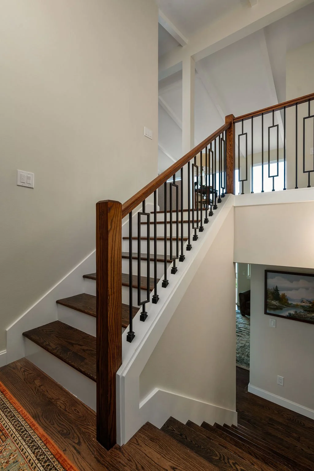 Close-up view of the staircase and custom railing in a Gig Harbor home remodel, completed by a remodeling contractor with wood treads and Deco-inspired balusters.