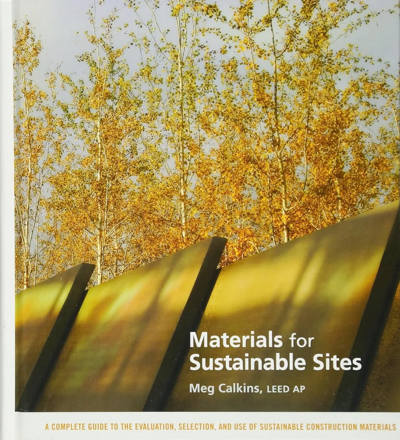 Cover of Materials for Sustainable Sites by Meg Calkins featuring large stone sculptural pieces framed by trees behind