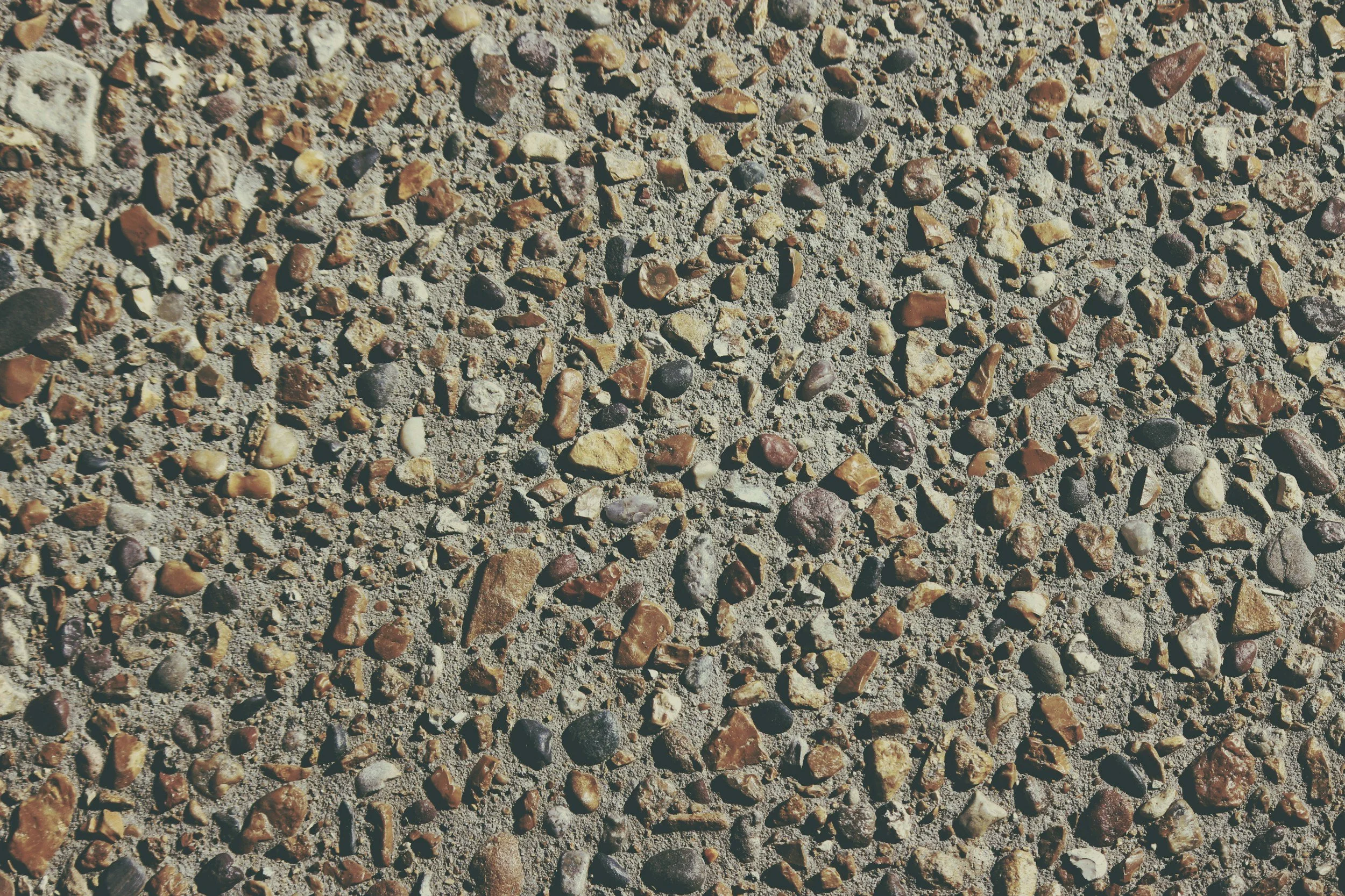 Exposed aggregate concrete featuring a variety of stones and recycled content