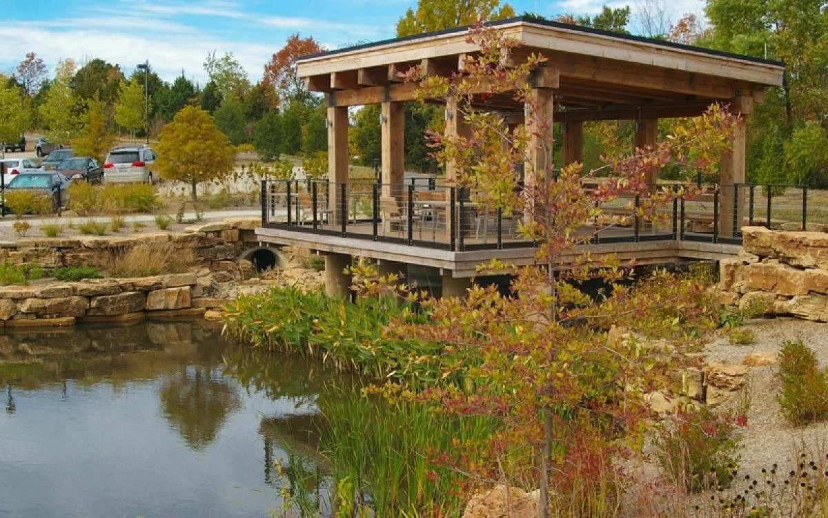 Novus International Headquarters Campus featuring a pavillion overlooking open water with native plants and stones surrounding it
