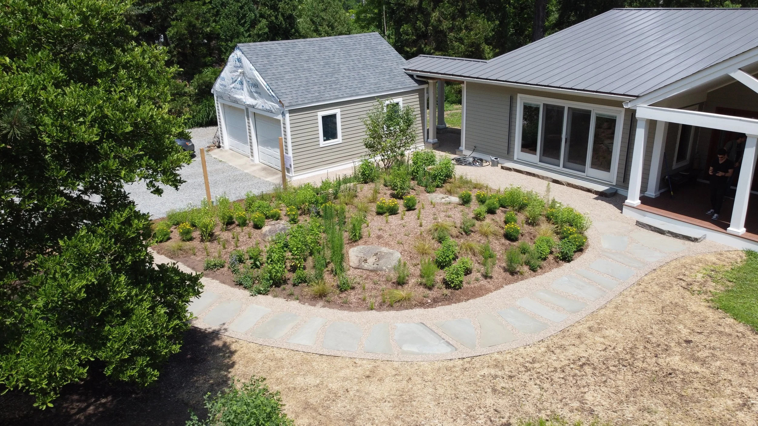 Native Knoll perennial garden wrapped in local stone path_drone.JPG