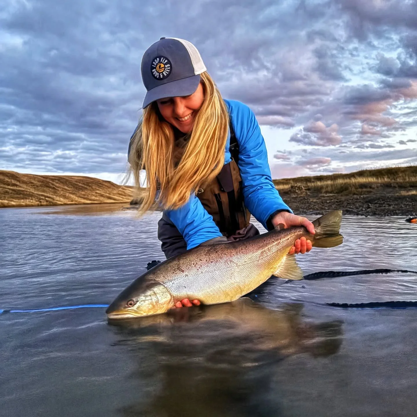 Woman catches huge sea-run brown trout in Rio Menendez with Wuijoor Lodge and Isolation Outfitters
