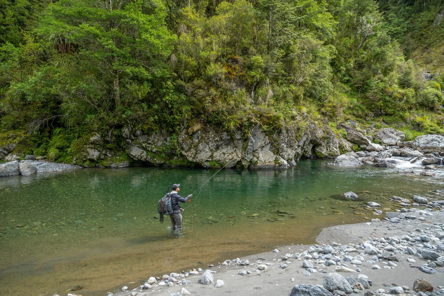 Fly fisher exploring New Zealand South Island backcountry water