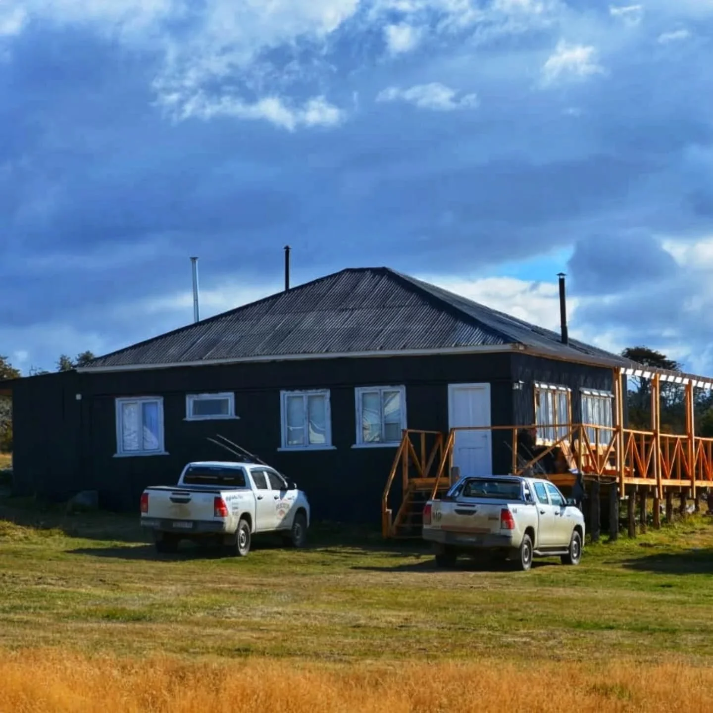 Wuijoor Lodge painted black with two Guide's trucks parked outside - Isolation Outfitters