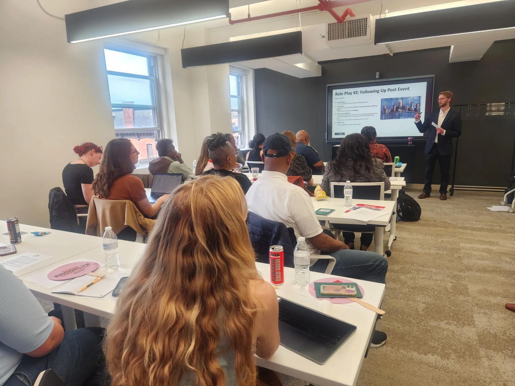 Fundraising Coach Mike Esposito is giving a presentation to a room full of nonprofit fundraisers at Brooklyn Org's Office.