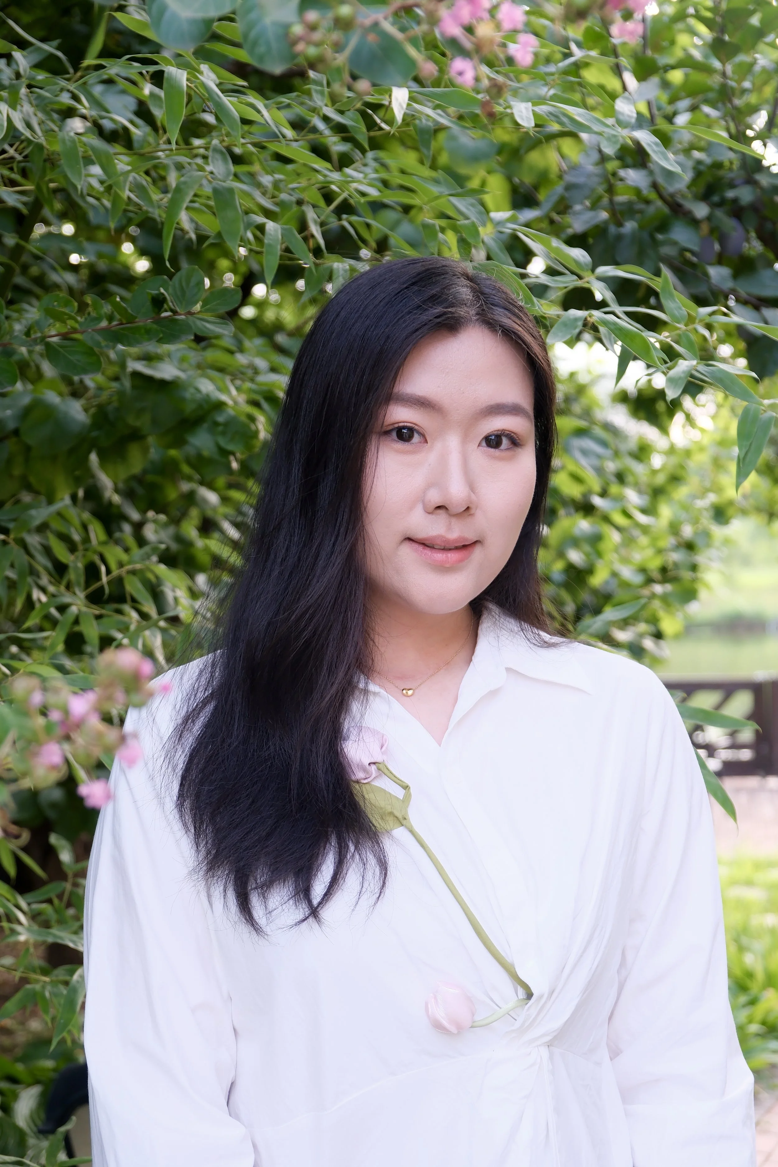 Seattle in person and virtual therapist Xinlei stands outside by a tree, smiling slightly at the camera. Xinlei provides in person and virtual therapy for immigrants, teens, and adults struggling with depression, anxiety, PTSD, and chronic illness.