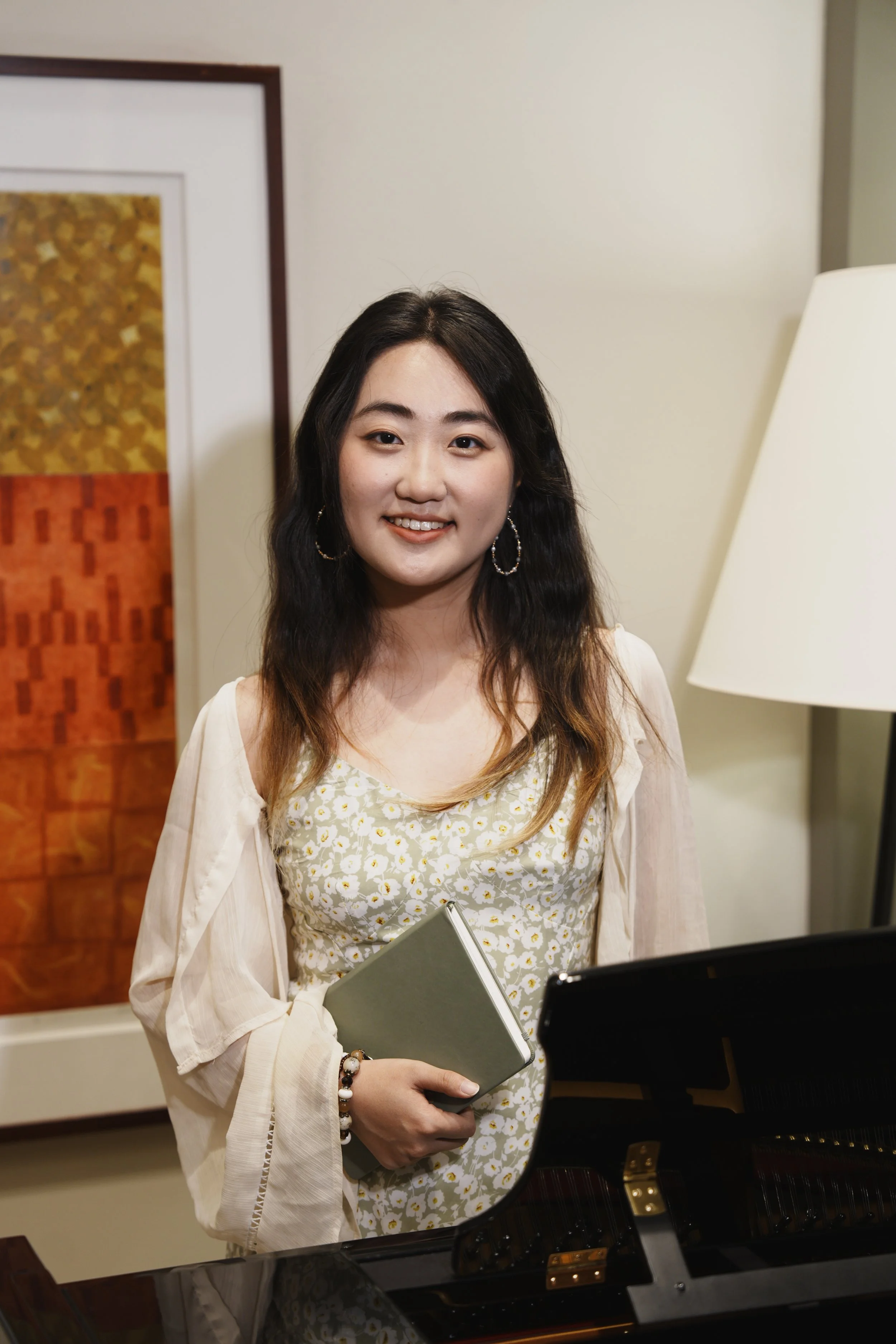 Seattle multicultural therapist stands at her desk holding a notebook. Nora provides therapy to immigrants, college students, teens, and those struggling with depression, anxiety and PTSD.