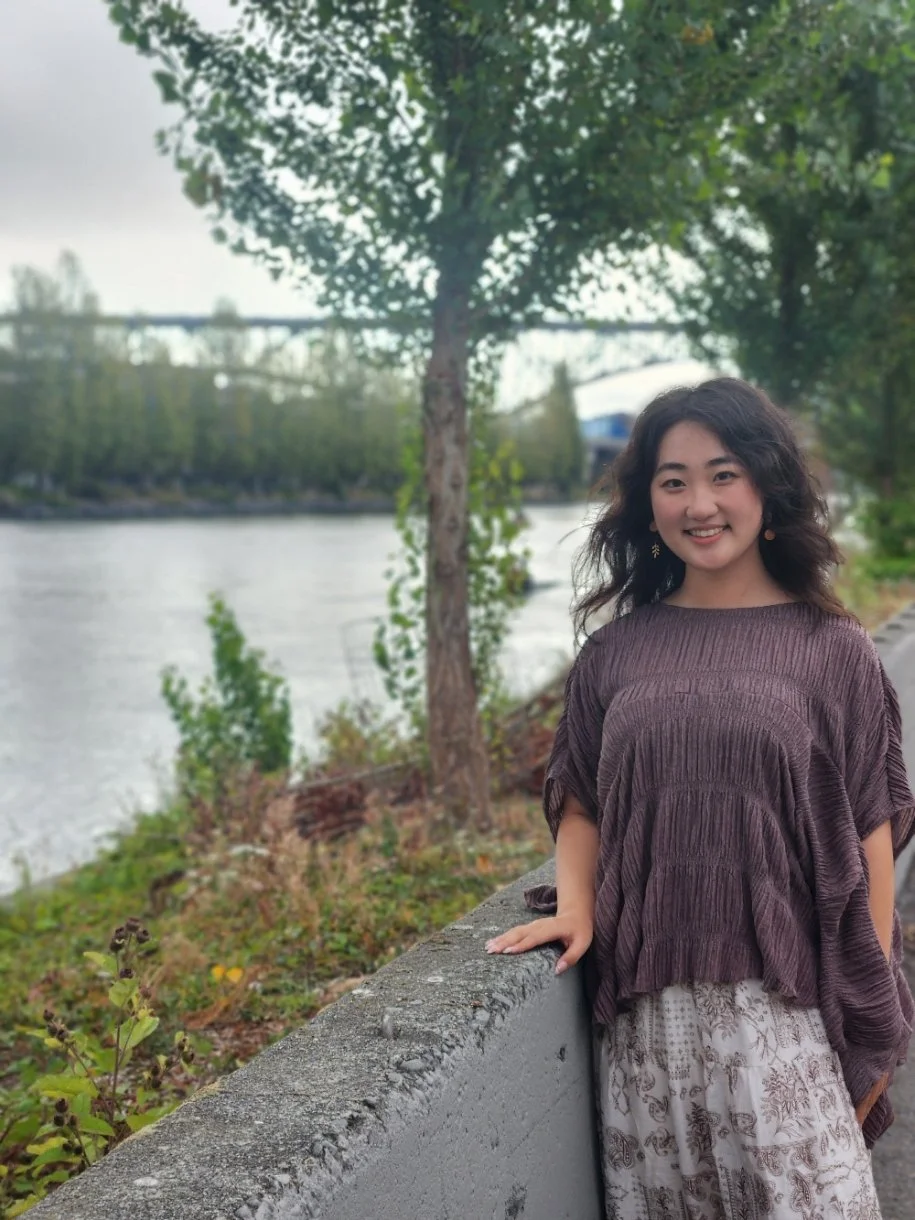 A BIPOC therapist stands by the canal in Queen Anne near Fremont. She specializes in working with immigrants, anxiety, depression, and trauma/PTSD.