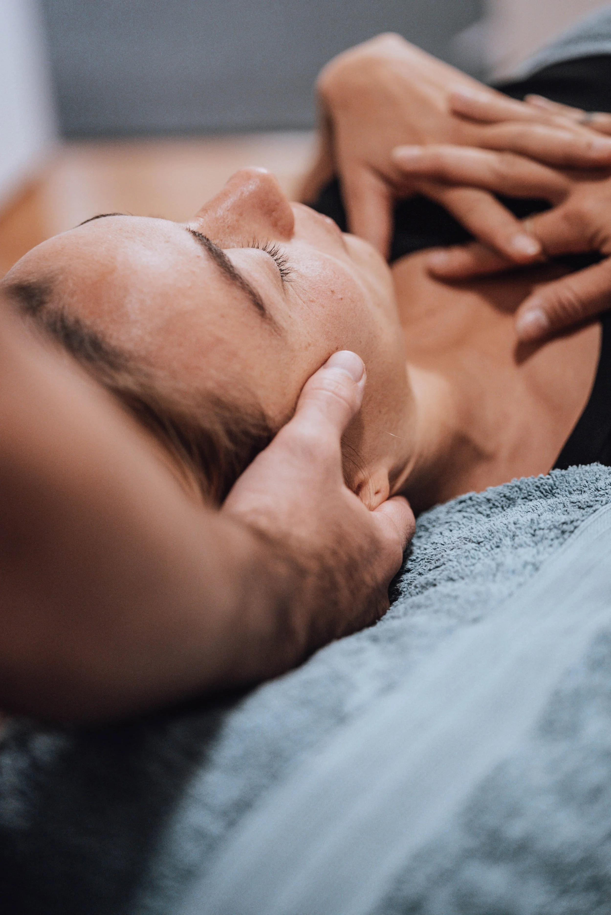 Osteopath gently treating a patient's head and neck at Medela Osteopathy & Co, Tweed Heads