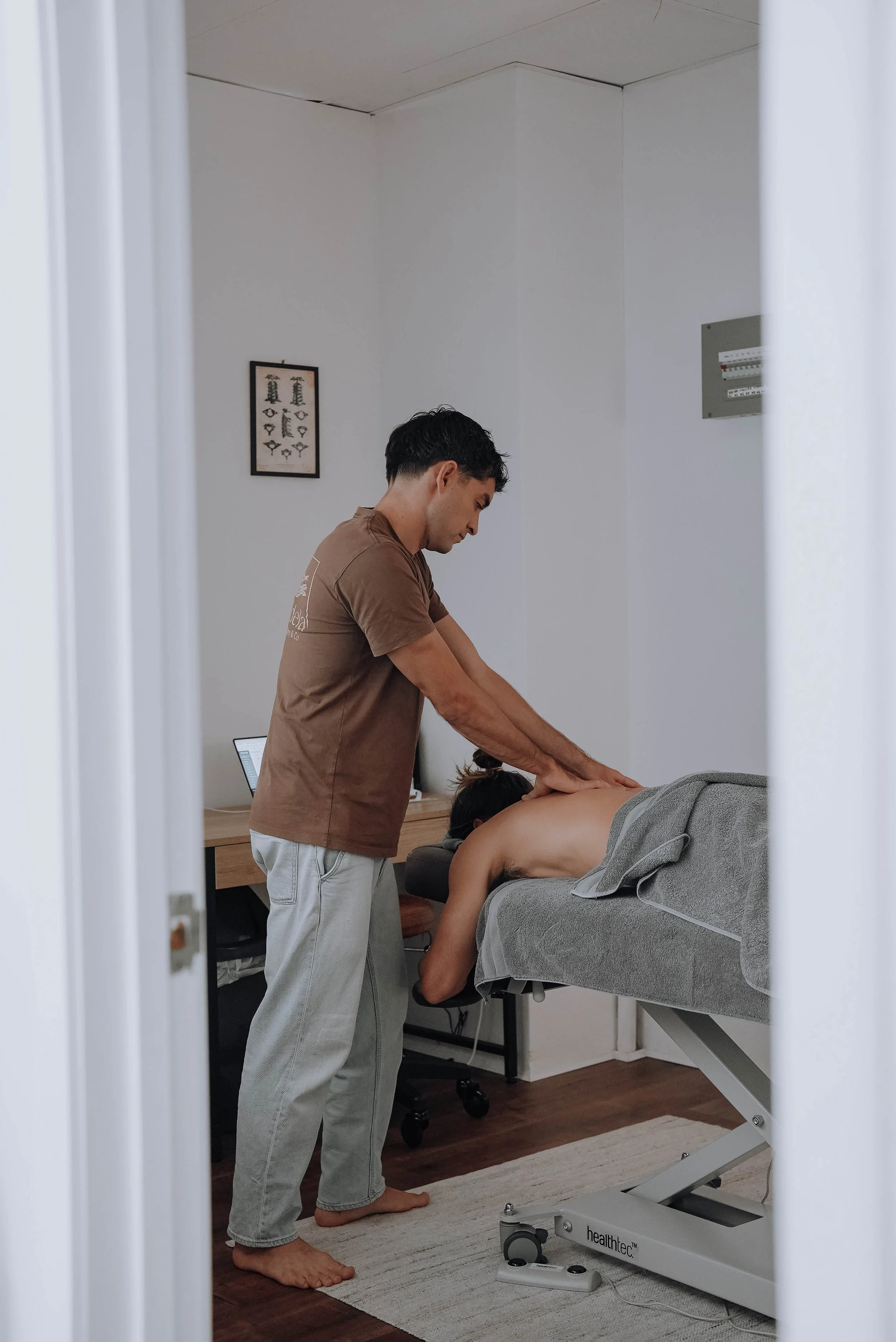 Osteopath treating a patient's upper back and shoulders during a headache and migraine appointment at the Tweed Heads clinic