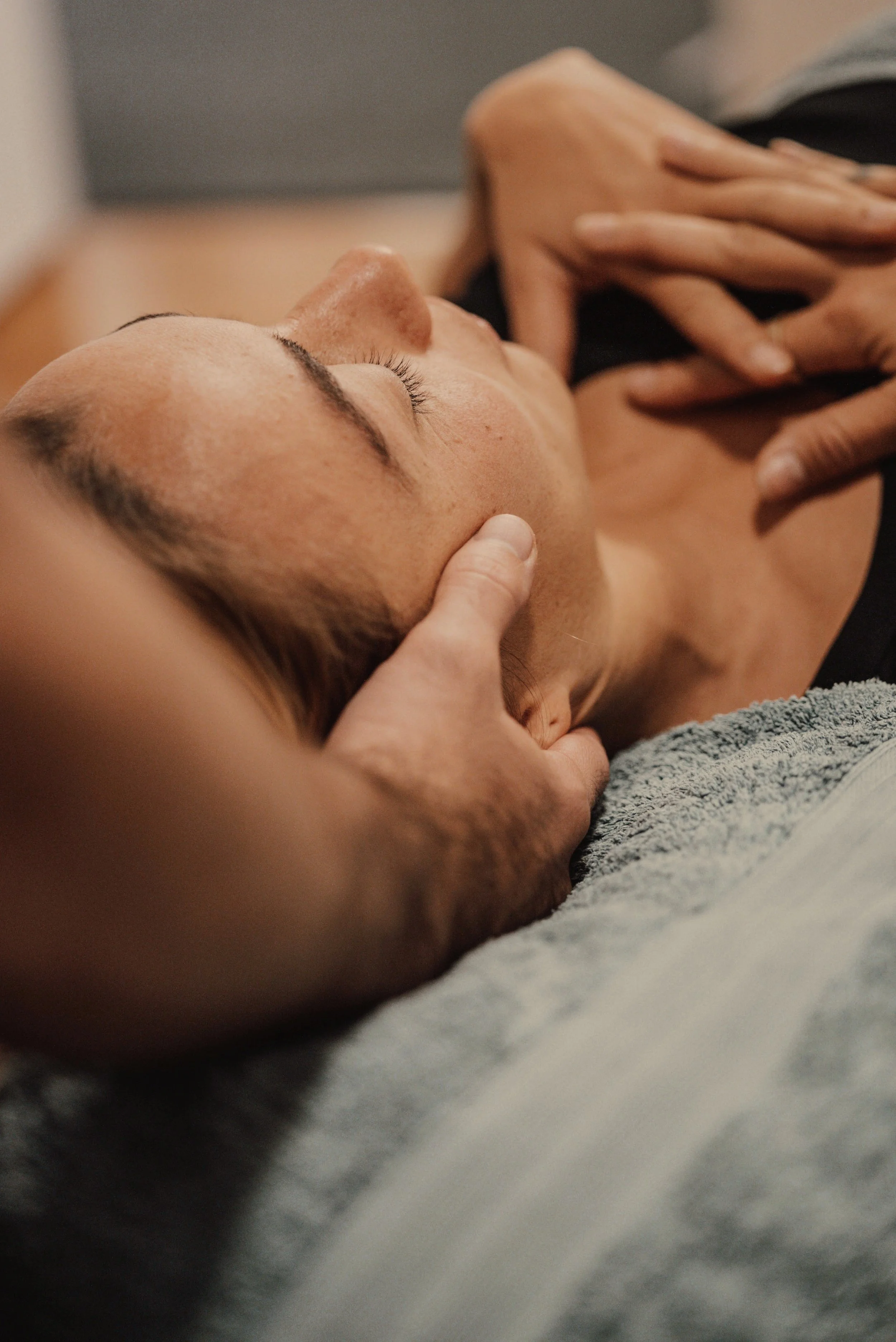 Osteopath gently treating the upper neck and base of the skull during a headache and migraine appointment
