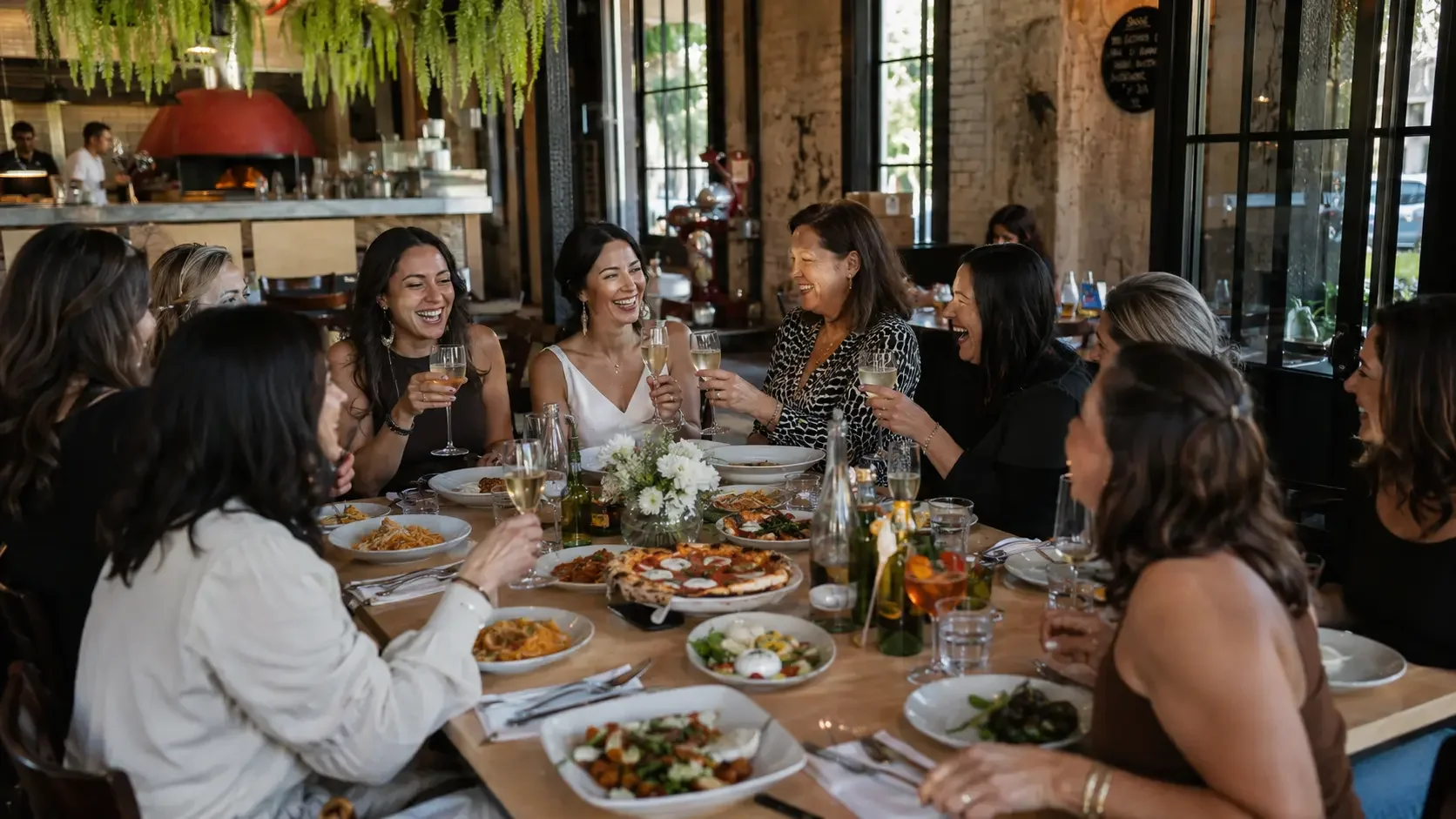 Group of bridal shower guests laughing and toasting with prosecco at a lunch in Sydney